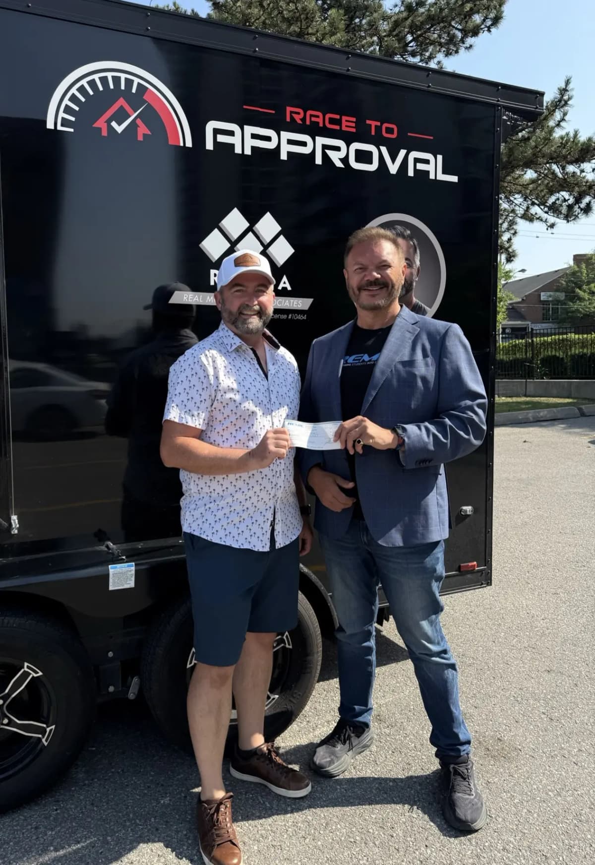 Carey Brooks receiving the REMIC #FundMyDream award in front of the Race To Approval trailer